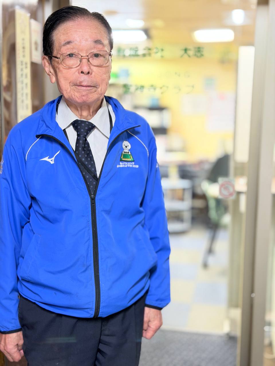 店の入口に立つオーナー（全国麻雀段位審査会 会長）